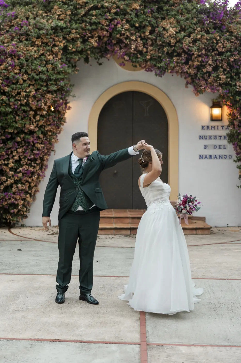 Los novios bailan frente a una ermita cubierta de buganvilla