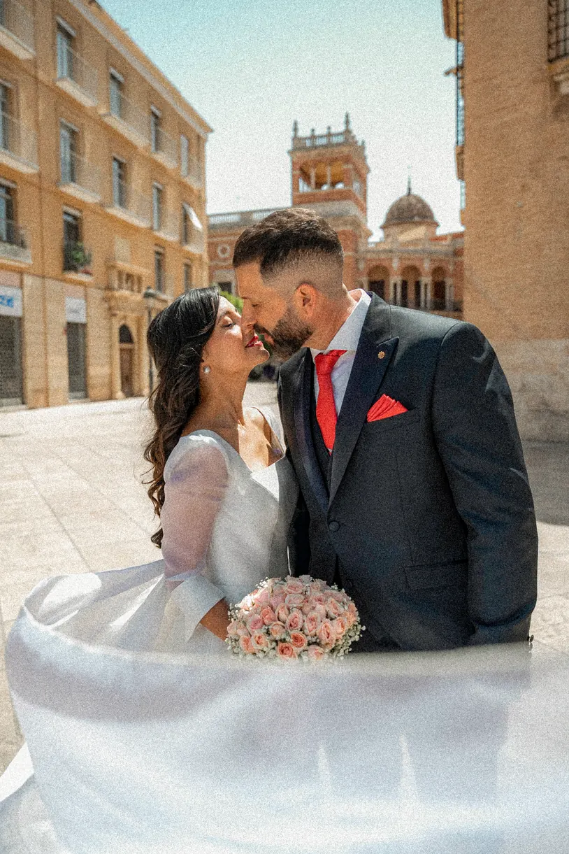 Beso de los novios en una plaza