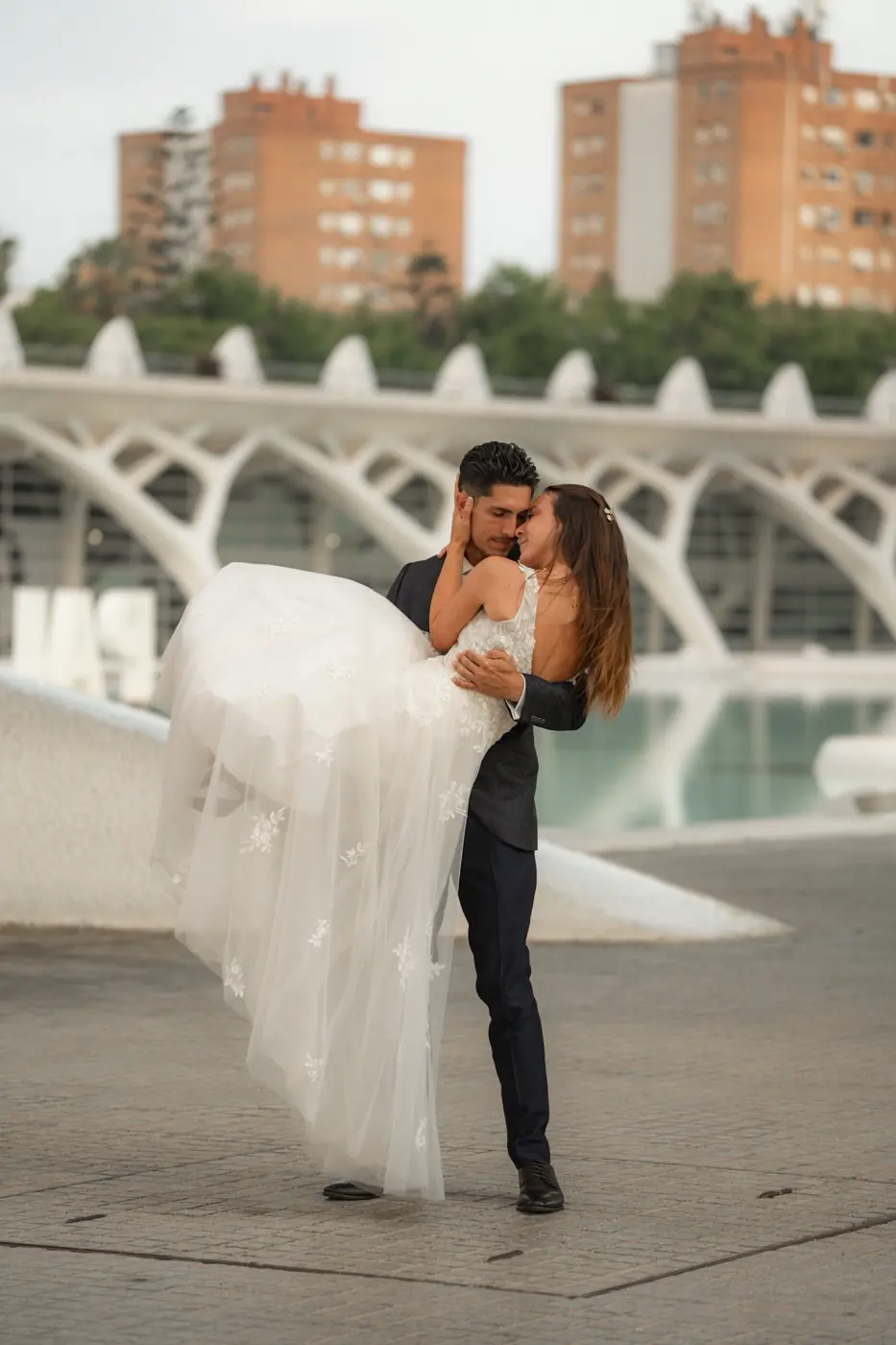 El novio coge en brazos a la novia en la Ciudad de las Artes