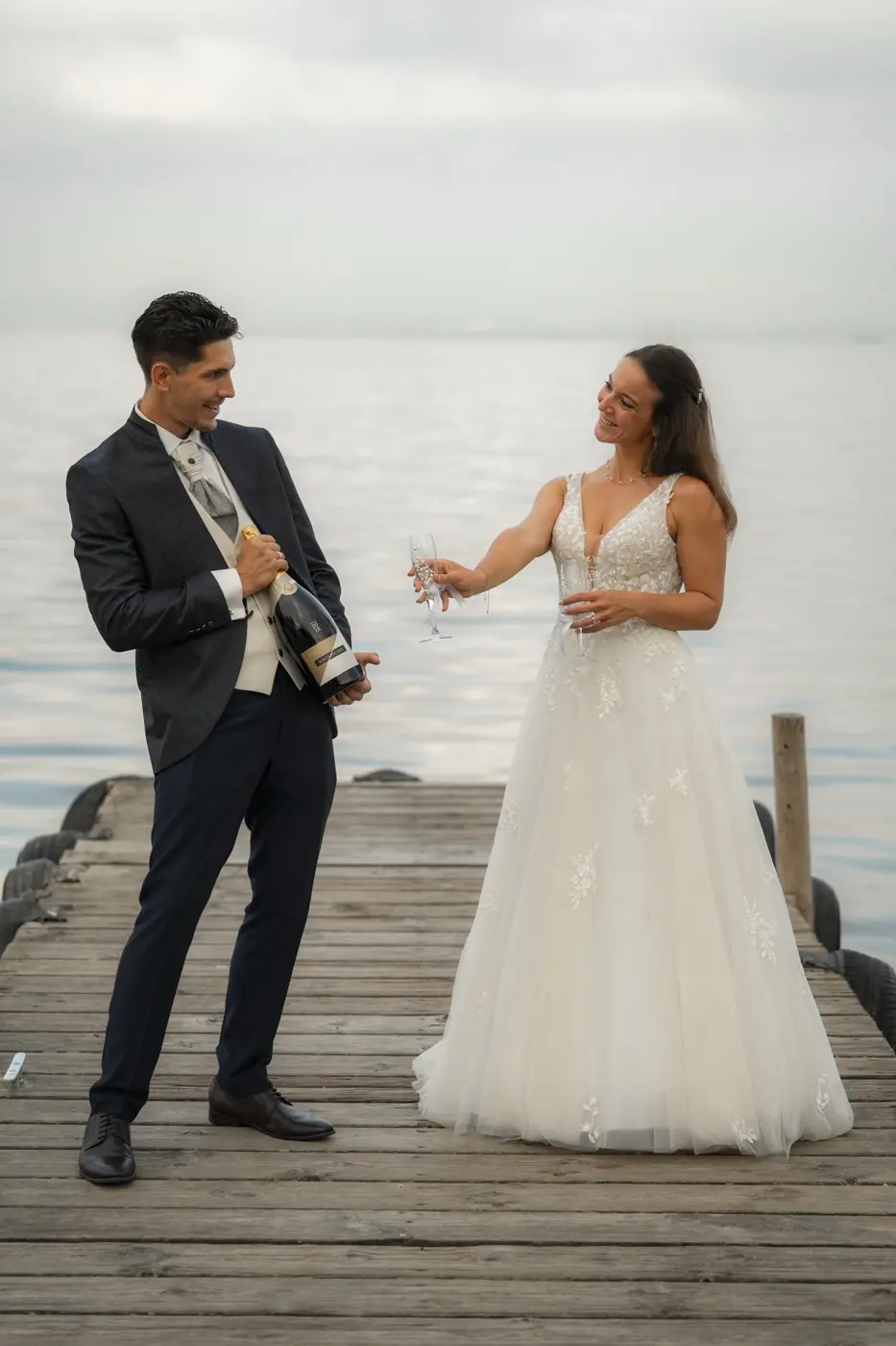 El novio abre el champán en el embarcadero