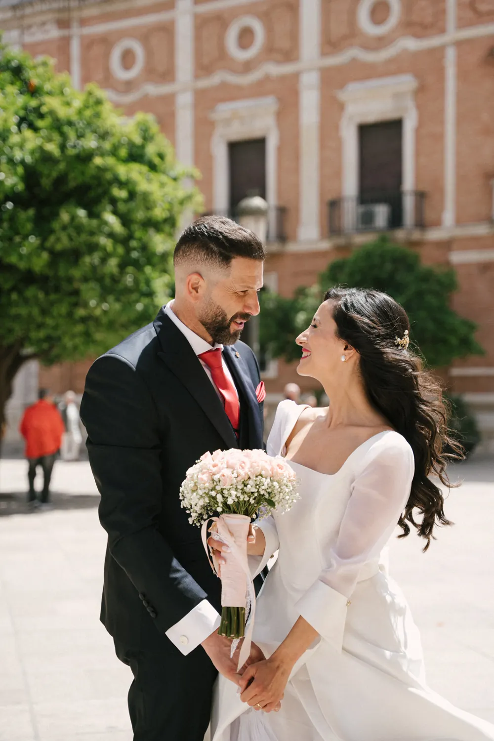 Los novios se miran sonriendo en una plaza de Valencia