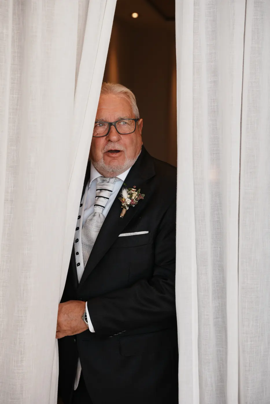 El padre de la novia asoma entre las cortinas
